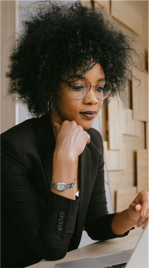 Black woman reading from a laptop computer